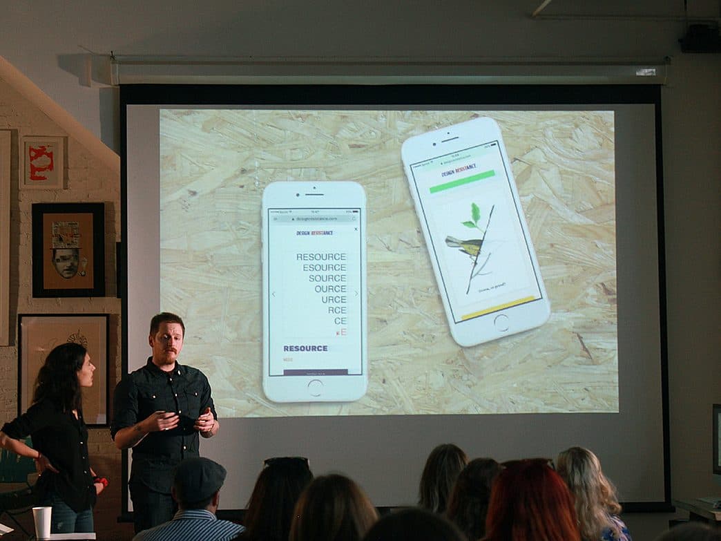 Two people are giving a presentation to an audience. They stand in front of a projector screen displaying two phone screens. The image on the right phone depicts a plant, while the left phone displays the text "RESOURCE" repeated multiple times.