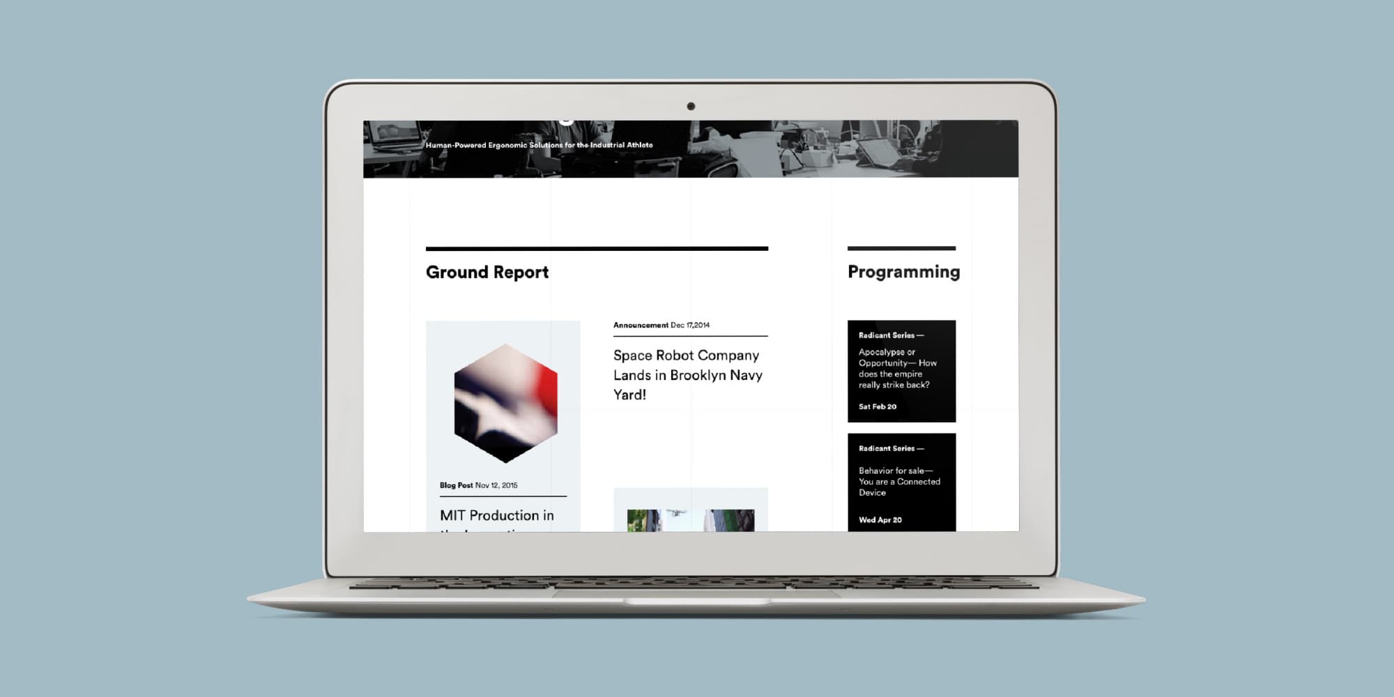 A laptop displaying a webpage with sections titled "Ground Report" and "Programming". The "Ground Report" section includes the headline "Space Robot Company Lands in Brooklyn Navy Yard" and a hexagonal image. The "Programming" section lists various event updates.