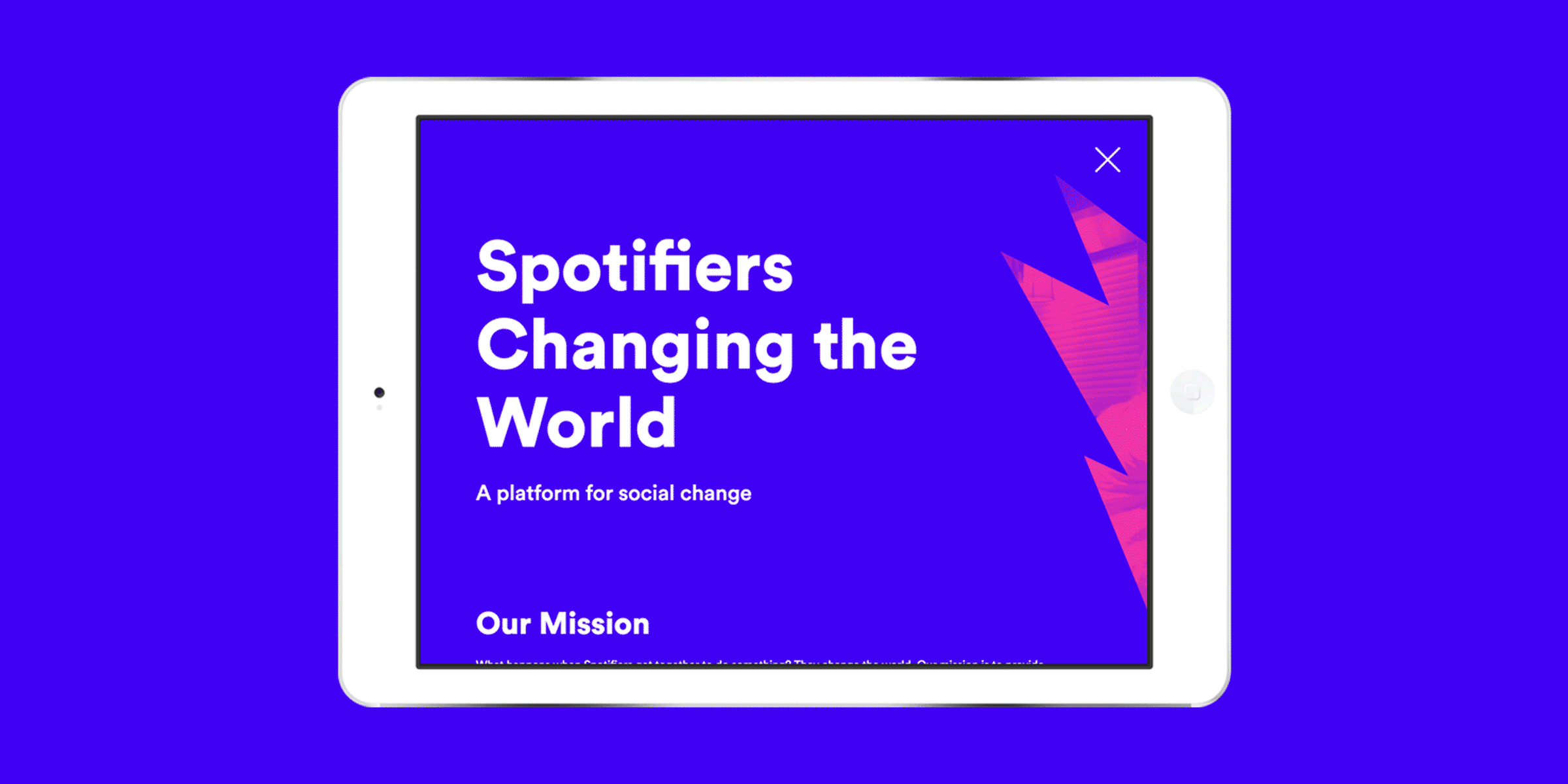 A tablet with a screen displaying a purple background and white text that reads, "Spotifiers Changing the World" and "A platform for social change." There is also a section titled "Our Mission" and a partial red graphic element on the right.