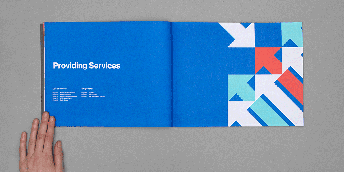 An open book showing two pages: the left page features the title "Providing Services" and a list of contact locations, with a hand holding the page. The right page displays abstract, geometric shapes in blue, white, and red on a gray background.