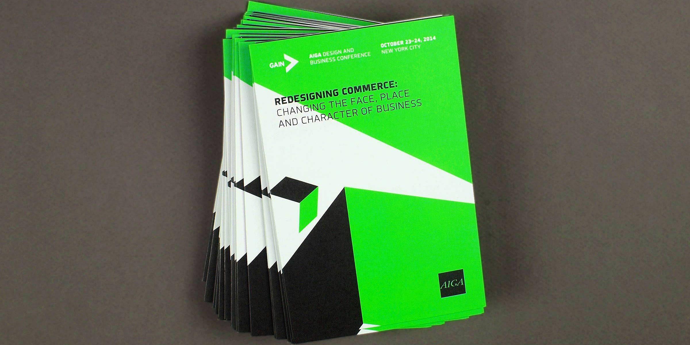 A stack of green and black booklets lies against a gray background. The top booklet reads "Redesigning Commerce: Changing the Place, Place, and Character of Business" with event details at the top: "AIGA GAIN Design and Business Conference, October 23-24, 2014, New York City.