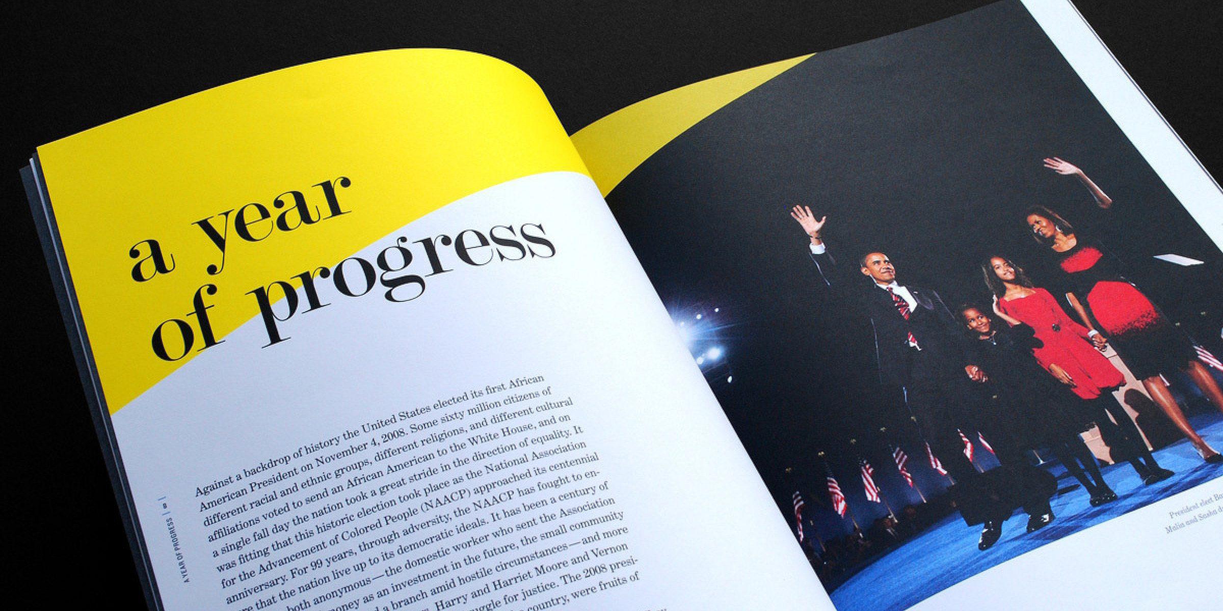 An open magazine showing a two-page spread. The left page has a large yellow section at the top with the text "a year of progress." The right page features a photo of four people standing on stage, waving, with U.S. flags in the background.