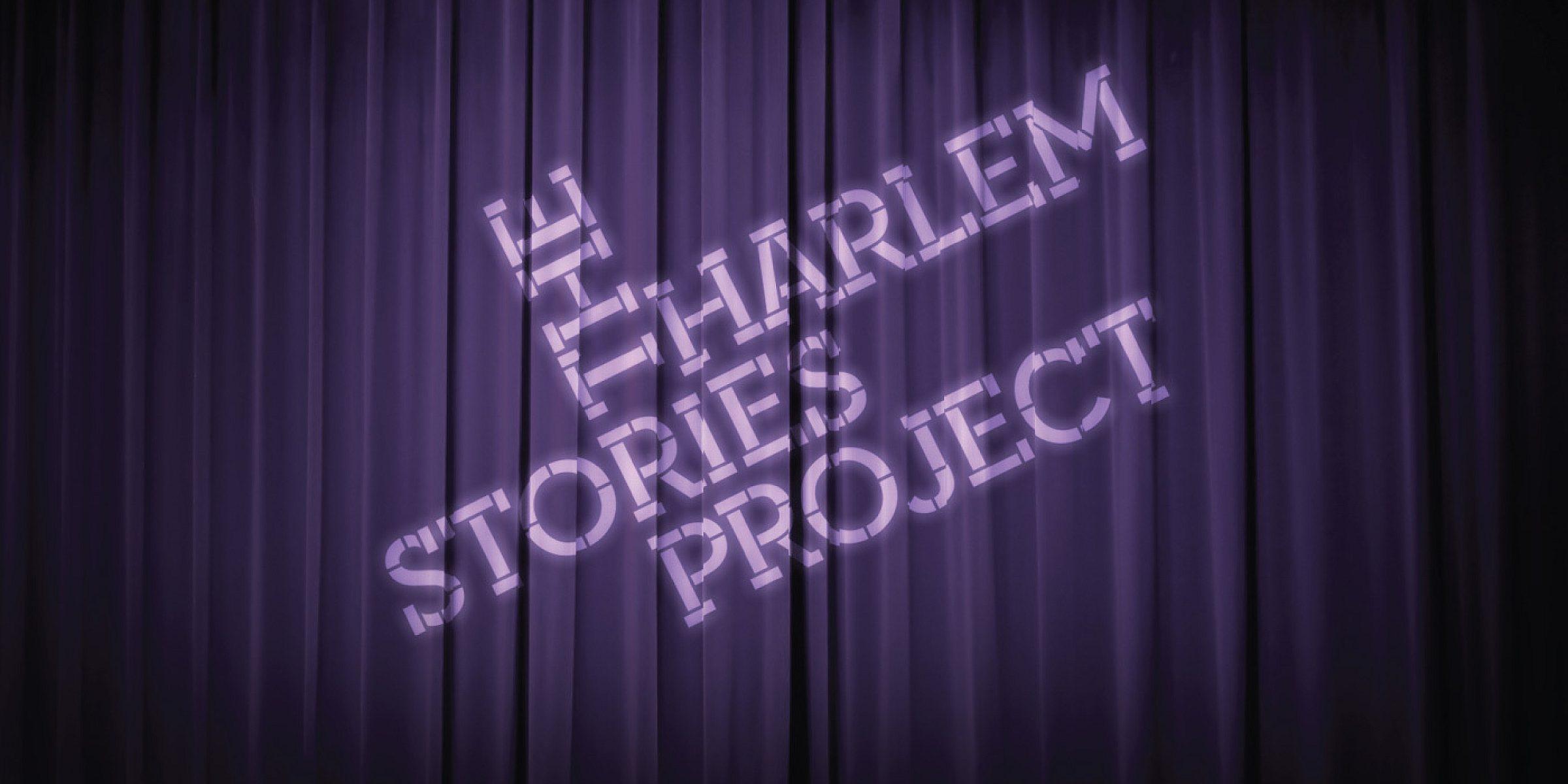 A purple curtain with the words “The Harlem Stories Project” projected onto it in white lettering. The text has a diagonal slant from the bottom right to the top left. The curtain has vertical folds and drapes down to the floor.