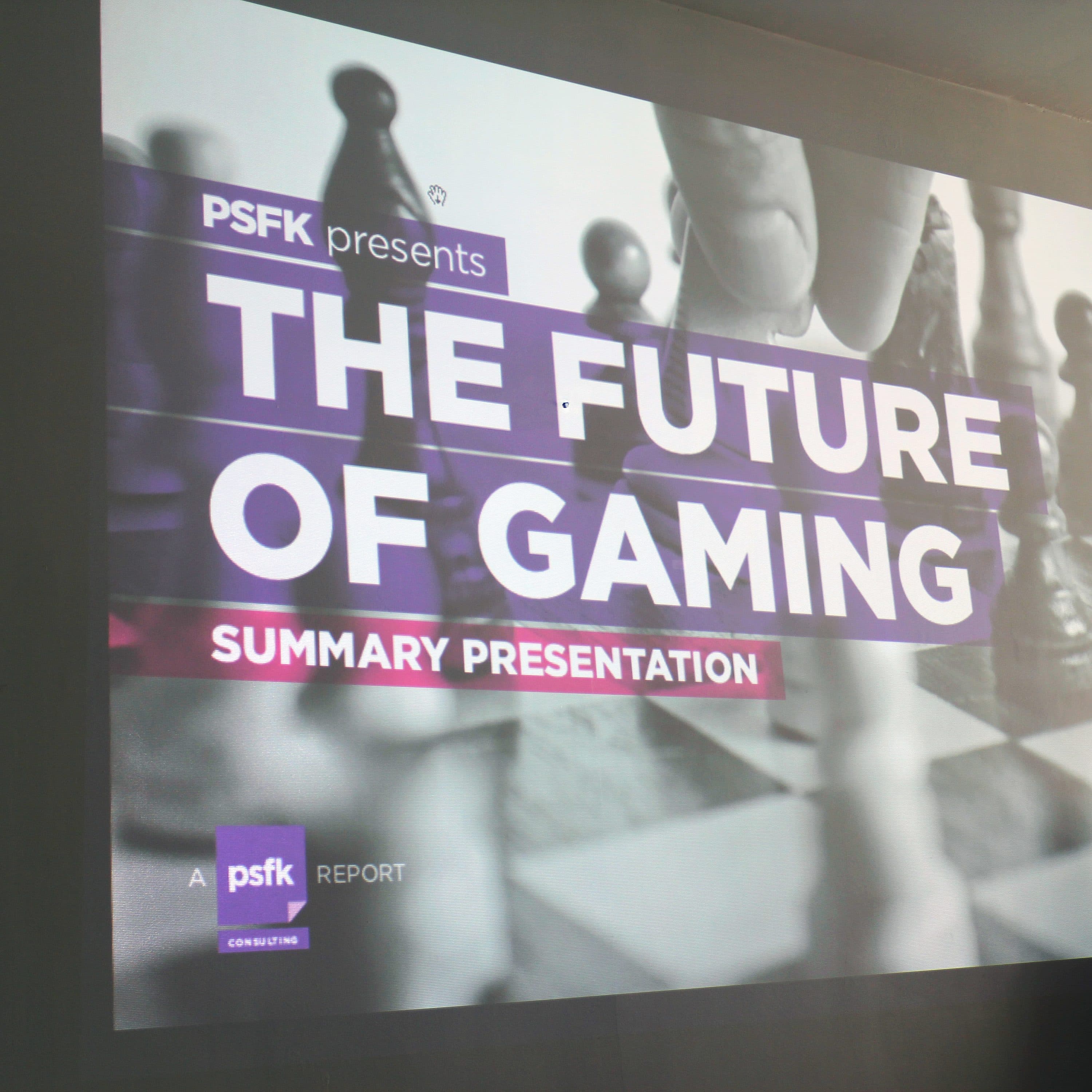 A presentation slide is displayed on a screen, titled "PSFK presents THE FUTURE OF GAMING, SUMMARY PRESENTATION." The background features a black and white image of a person moving a chess piece. A psfk report badge is visible at the bottom left.