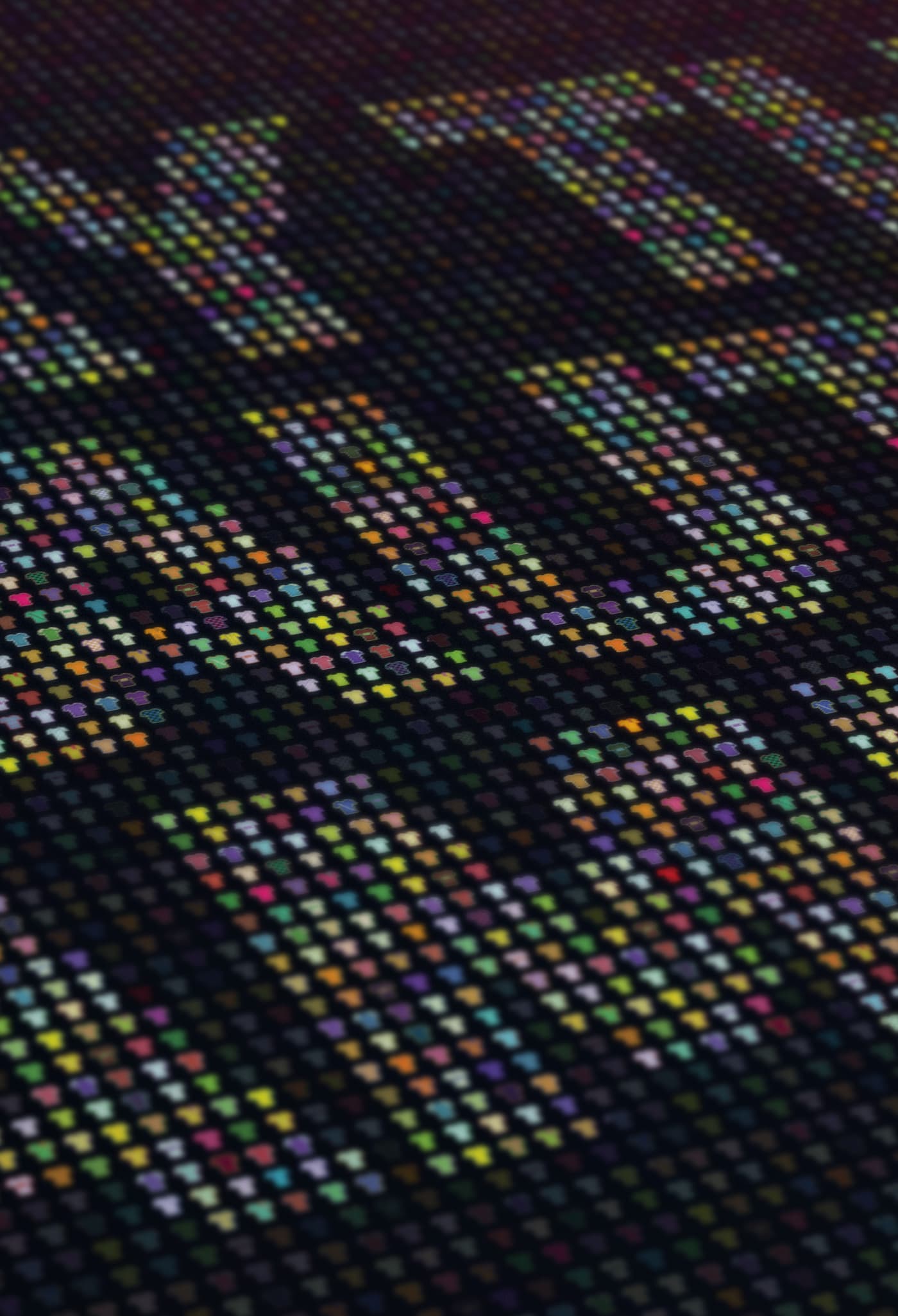 Close-up of a colorful LED display showing pixelated text. The individual LED pixels are visible, forming letters with various colors like blue, green, red, and yellow against a dark background. The overall appearance is vibrant and dynamic.