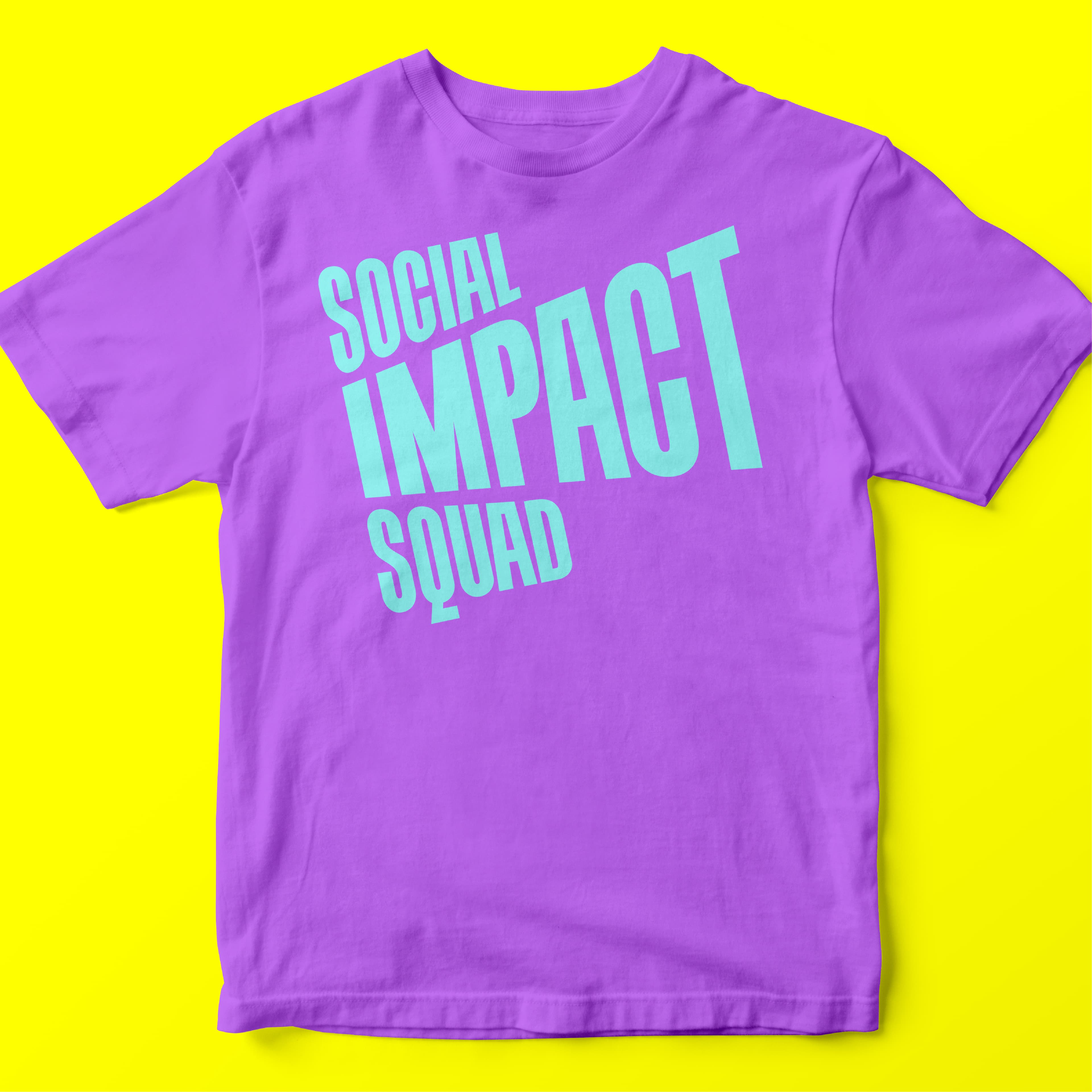 A purple t-shirt with bold, turquoise text that reads "Social Impact Squad" is displayed against a bright yellow background. The contrast of colors makes the text stand out prominently.